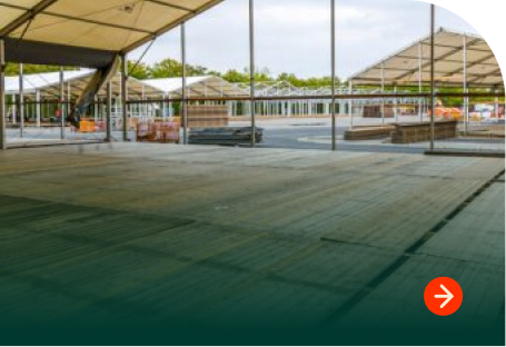 Temporary ground protection flooring installed under an outdoor event structure