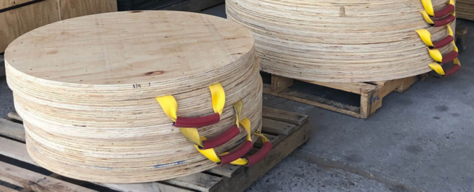 Stacks of round wood outrigger pads on pallets manufactured by Lodge Lumber in Houston, TX